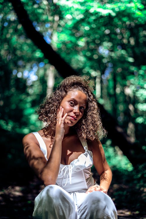 Beautiful Woman with Curly Hair Posing in the Forest