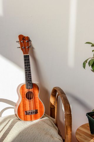 An acoustic guitar leaning against a wall