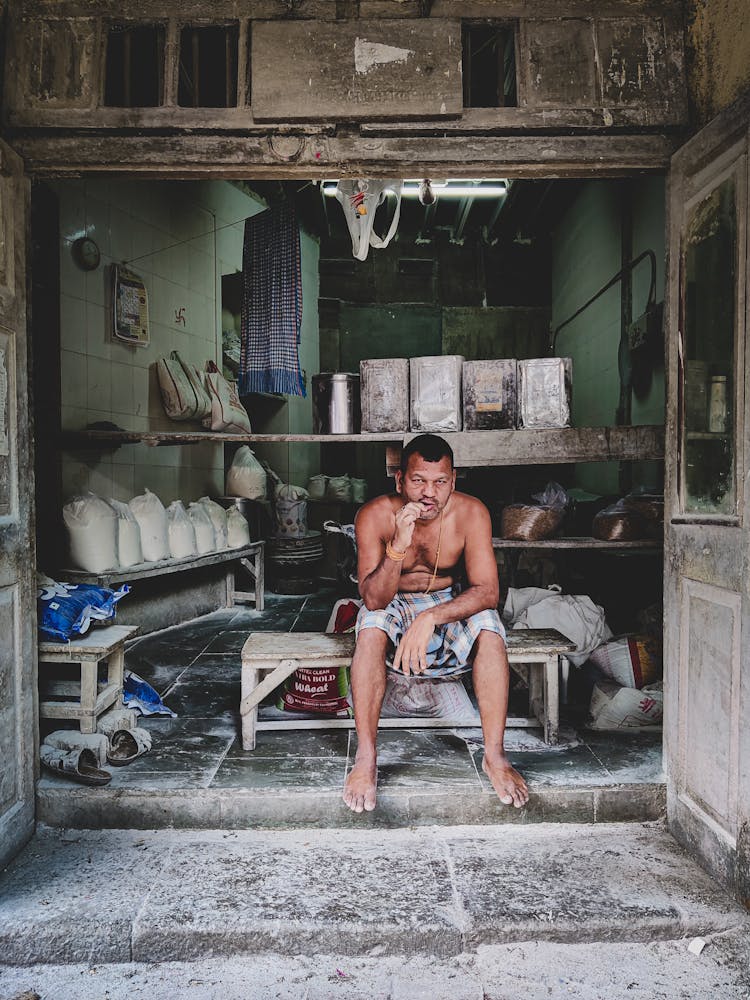 Man Sitting In Garage Smoking