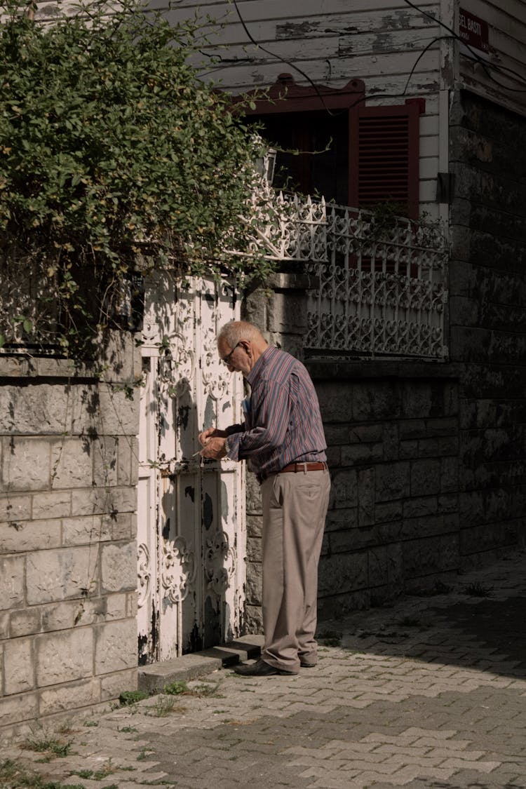 Man In Long Sleeves And Pants Opening The Door