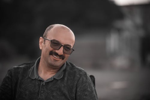 A Man in Gray Polo Shirt Smiling while Wearing Eyeglasses