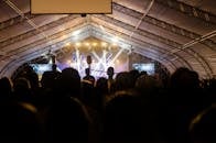 在明亮的聚光灯下，充满活力的人群正欣赏着一场引人入胜的室内音乐会