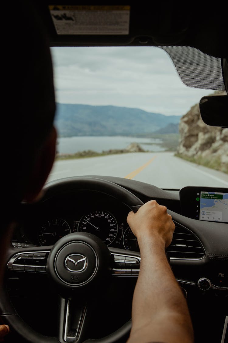 Man On Steering Wheel Driving On Empty Road