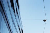 晴朗天空下，现代玻璃建筑与电线的透视图