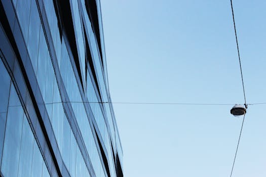 晴朗天空下，现代玻璃建筑与电线的透视图