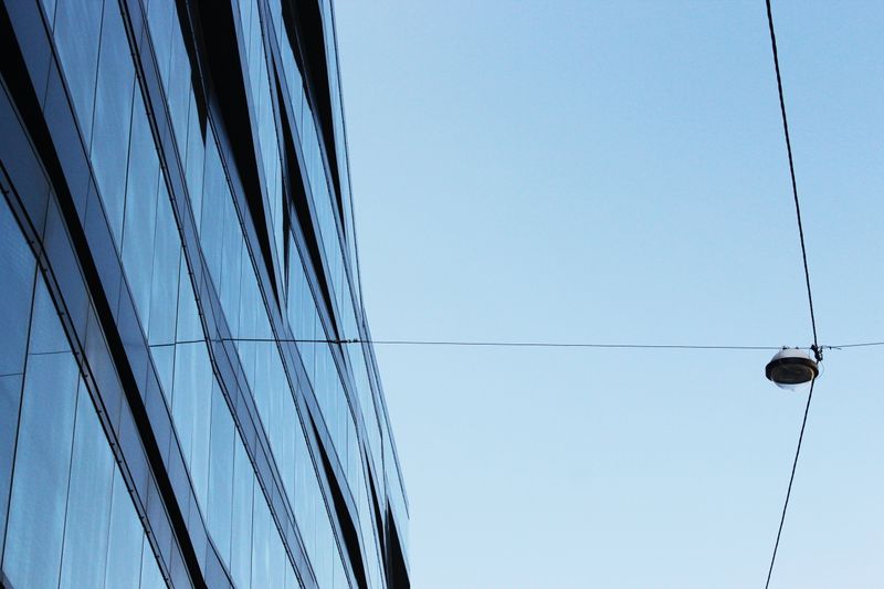 A modern glass office tower with overhead power lines