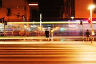 在热闹的市中心，夜晚的长曝光拍摄捕捉到了行人过街时城市灯光与运动的景象