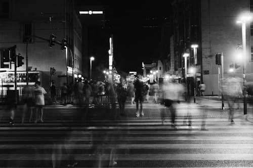 Group of People Crossing Pedestrian Lane in Greyscale