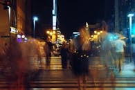 夜间，城市灯光让过马路的行人看起来有些模糊