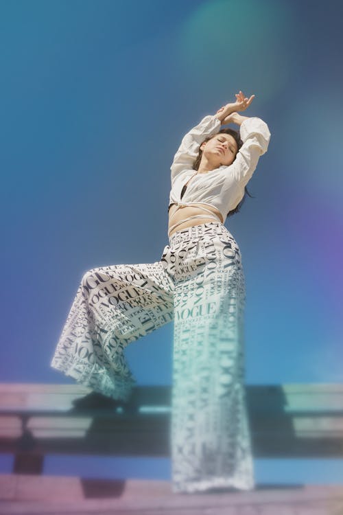 A Woman in white Long Sleeves and Printed Pants Posing