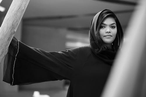 A Grayscale Photo of a Woman in Black Long Sleeves Wearing Hijab