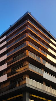 Contemporary urban building with a sleek glass facade against a clear blue sky