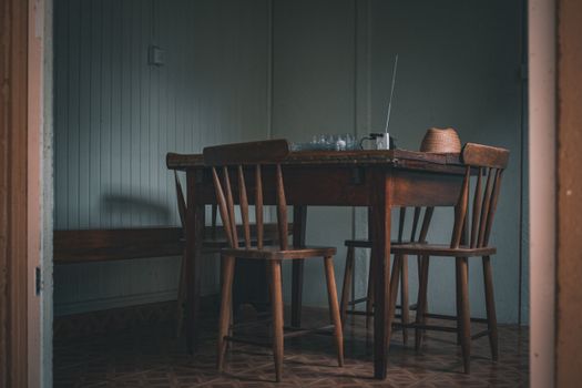 Cozy indoor scene featuring a wooden table and chairs, with a vintage radio.