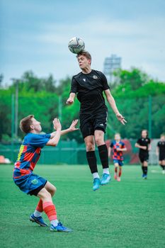 Two male soccer players compete intensely on a green field.