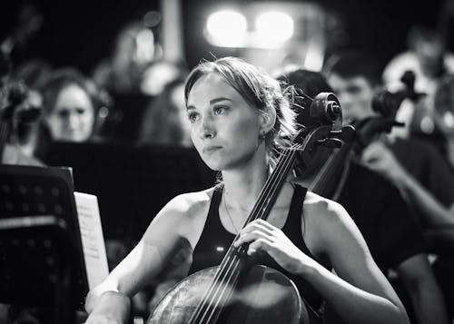 Grayscale Photo of a Beautiful Woman Playing a Cello