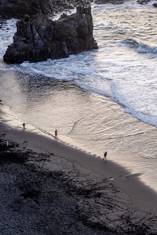 Photo of People Walking at a Beach