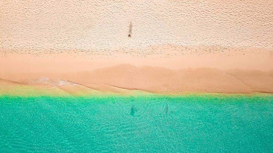 A breathtaking drone shot of Holetown Beach, Barbados, showcasing turquoise waters and golden sand.
