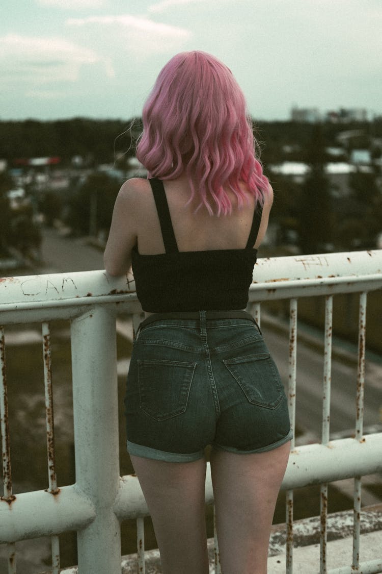 Back View Of A Woman Leaning On Metal Railing