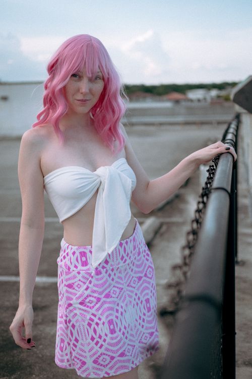 Free Stylish young woman with pink hair poses confidently outdoors in a fashionable outfit. Stock Photo
