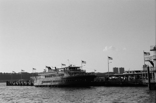 Free A docked ferry surrounded by American flags in a calm monochrome setting. Stock Photo