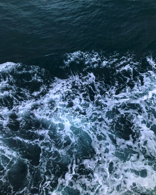 Top view of dynamic ocean waves crashing with white sea foam, showcasing nature's power.