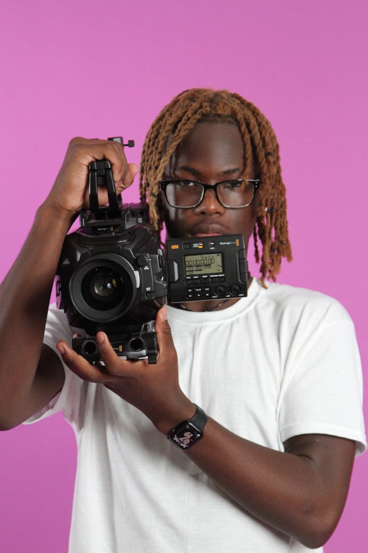 Young Man Holding A Professional Camera 