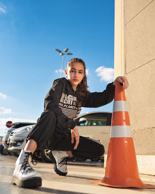 Pretty Girl Posing beside a Traffic Cone