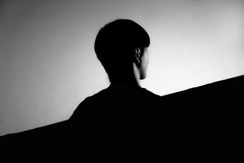Free Artistic black and white photo of a woman seen from behind with short hair. Stock Photo