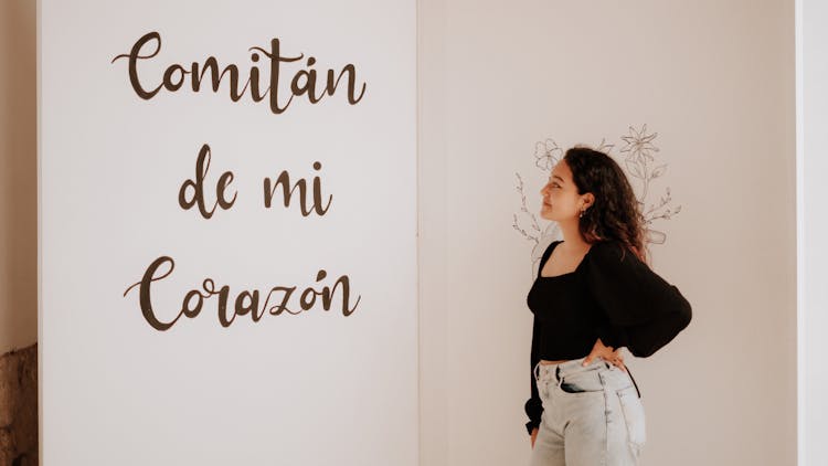 A Woman Looking At A Quotation On The Wall