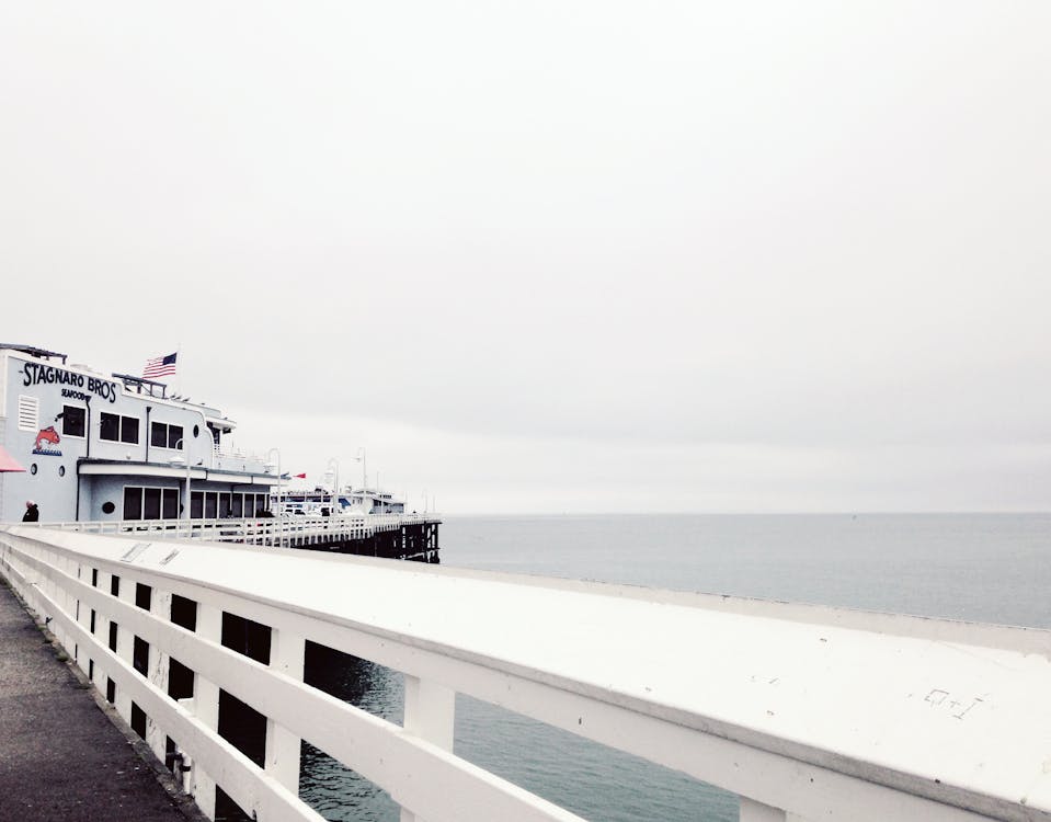 Free White Cruise Ship Near Concrete Dock on Body of Water Under White Cloudy Sky during Daytime Stock Photo