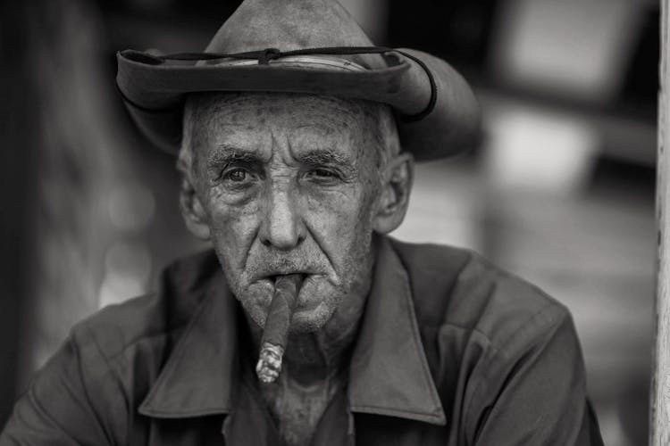 A Grayscale Of A Man Smoking A Cigar