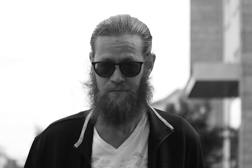 Grayscale Photo of a Man with a Beard Wearing Sunglasses