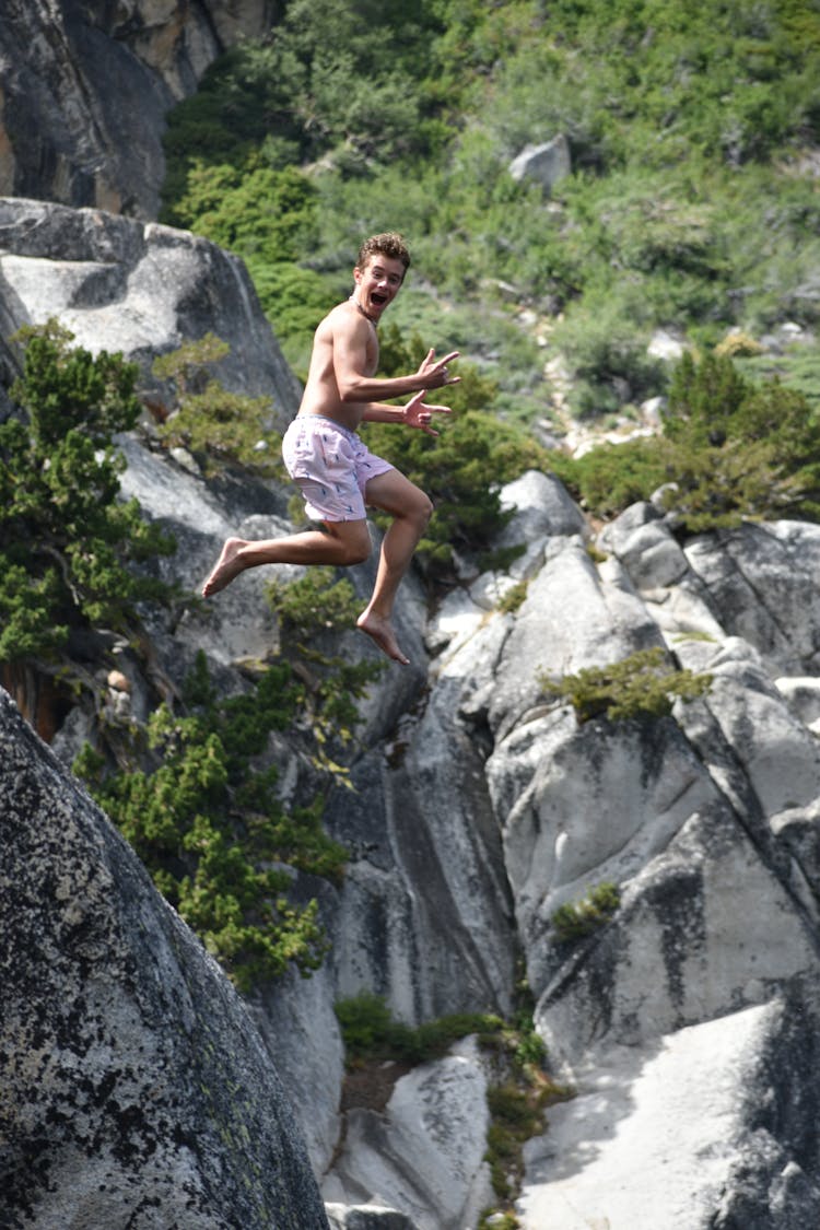 Young Man Jumping From A Cliff