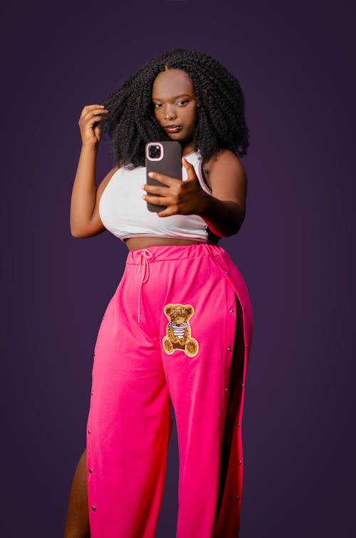 Curvy Woman in White Crop Top and Pink Pants Taking a Selfie
