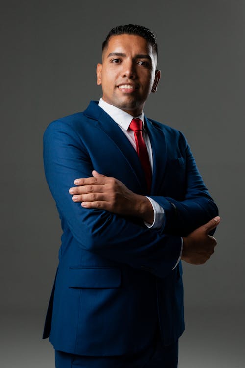 Man Wearing Blue Suit on Gray Background