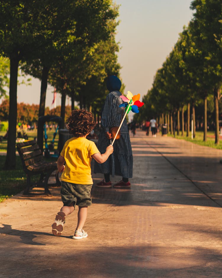 Back View Of A Boy Running With A Toy