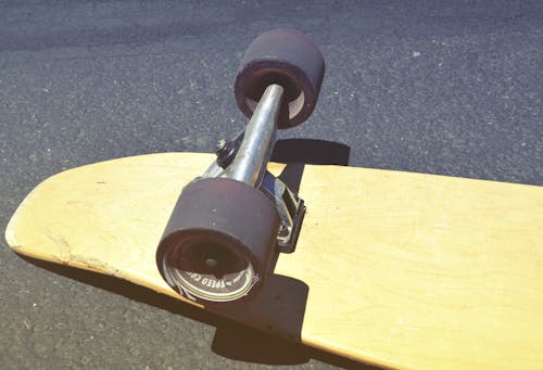 Коричневый скейтборд на бетонной дороге