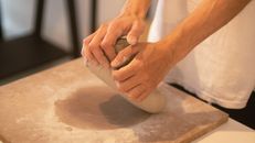 Close-up of hands kneading clay for pottery, showcasing the art and skill of Colombian artisans.