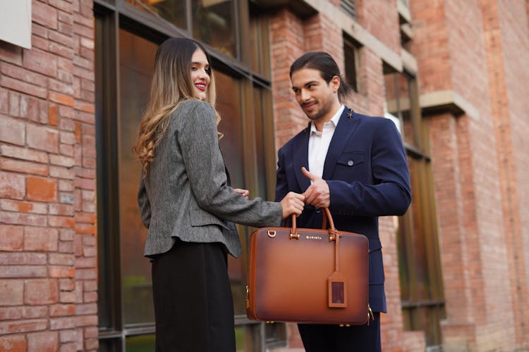 Man And Woman Holding Leather Briefcase