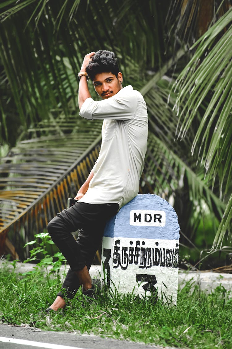 Man Leaning On A Boundary Marker