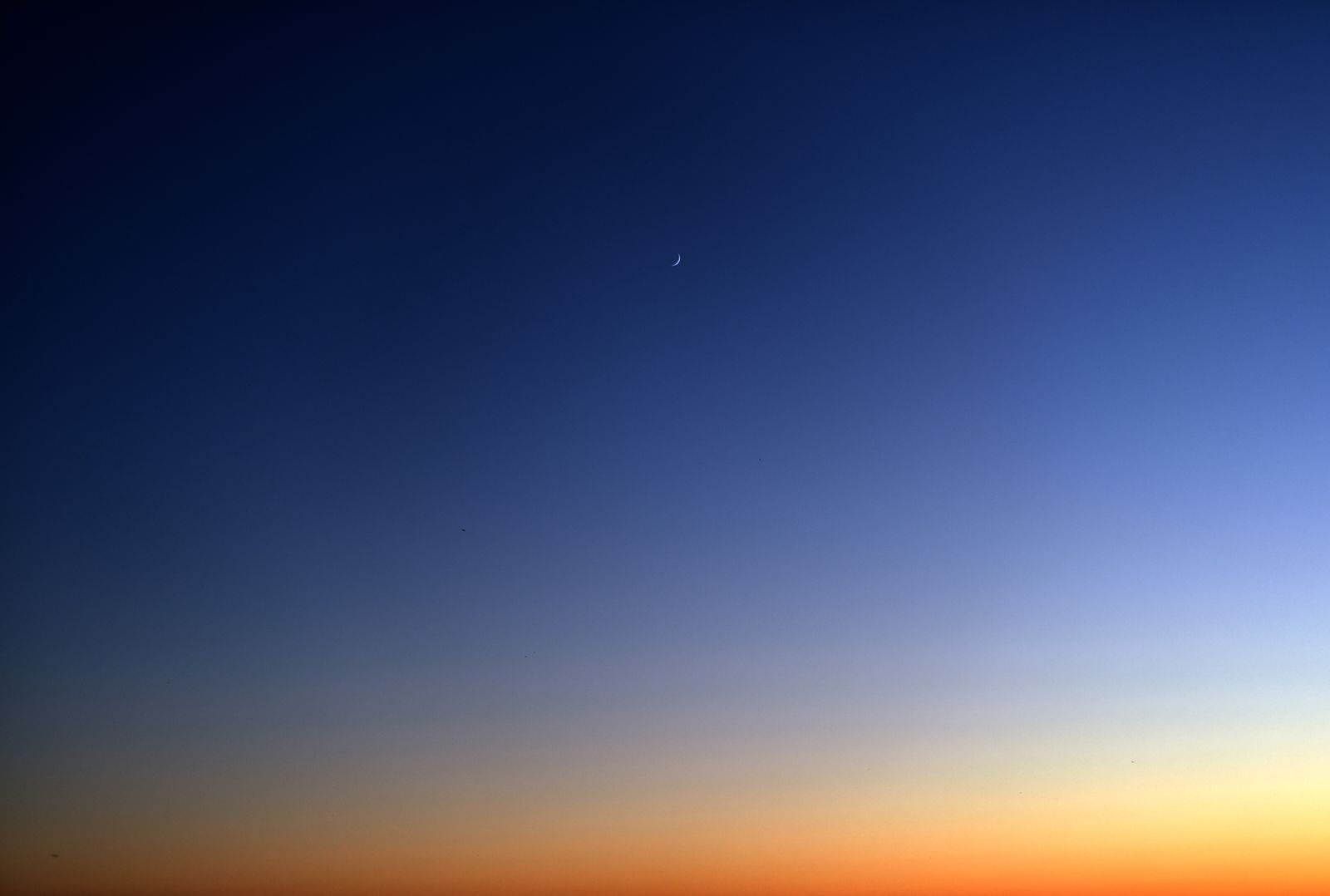 Beautiful twilight sky with a crescent moon and serene gradient of colors