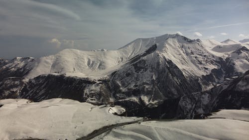 Snow Covered Mountains under White Clouds