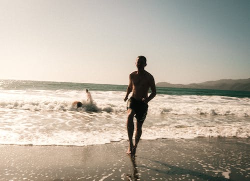Free Man running out of the water full of joy Stock Photo