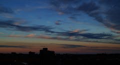 五颜六色的天空中，城市建筑的黑暗剪影映衬着迷人的日落