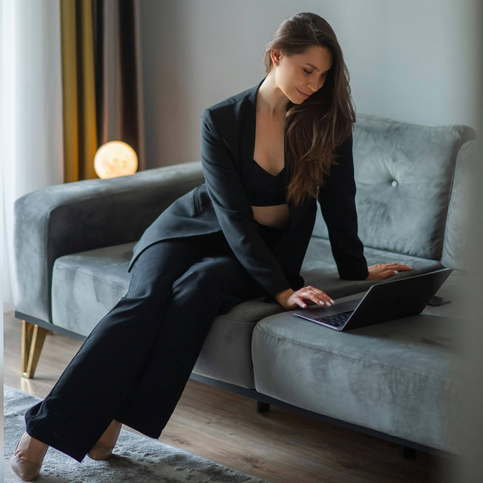 A Woman Using Her Laptop while Sitting on a Sofa