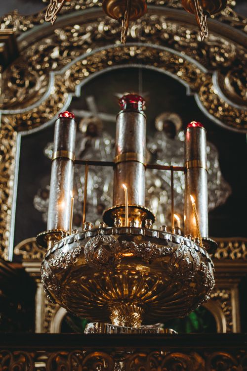 Free Close-up of intricately designed gold candle holder inside a cathedral or chapel setting, offering a luxurious feel. Stock Photo