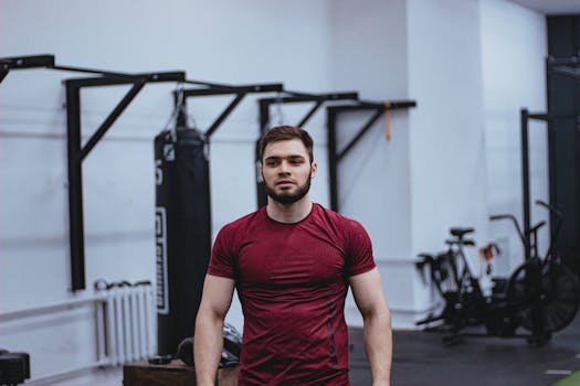 A fit young man standing confidently in a gym, displaying strength and focus.