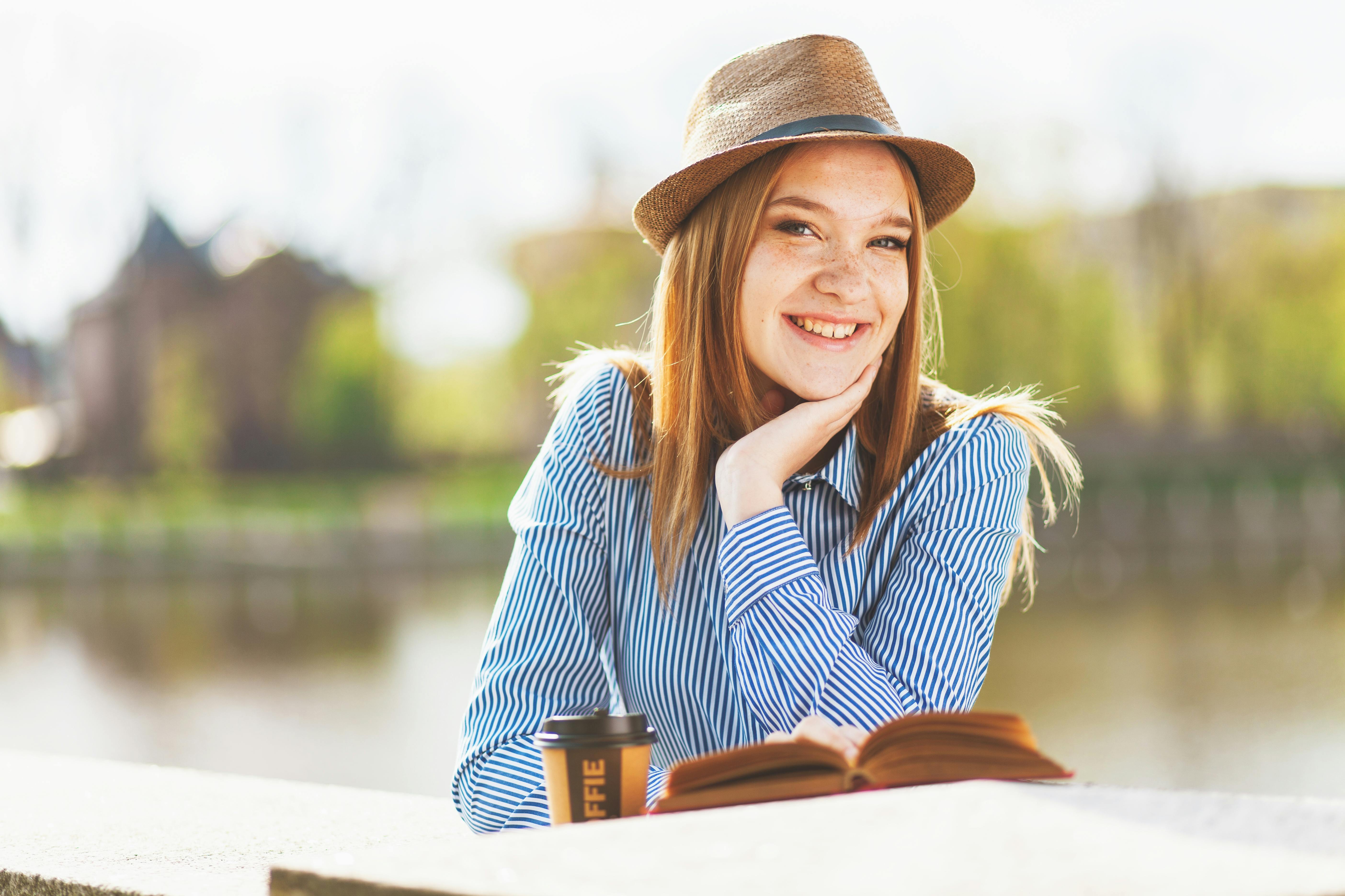 Focus Photography Smiling Woman While Reading Book Free Stock Photo