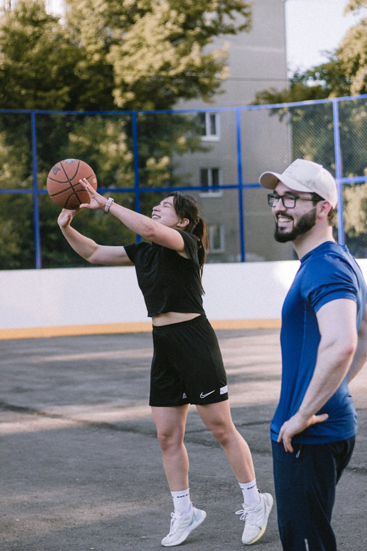 A Woman Shooting A Basketball