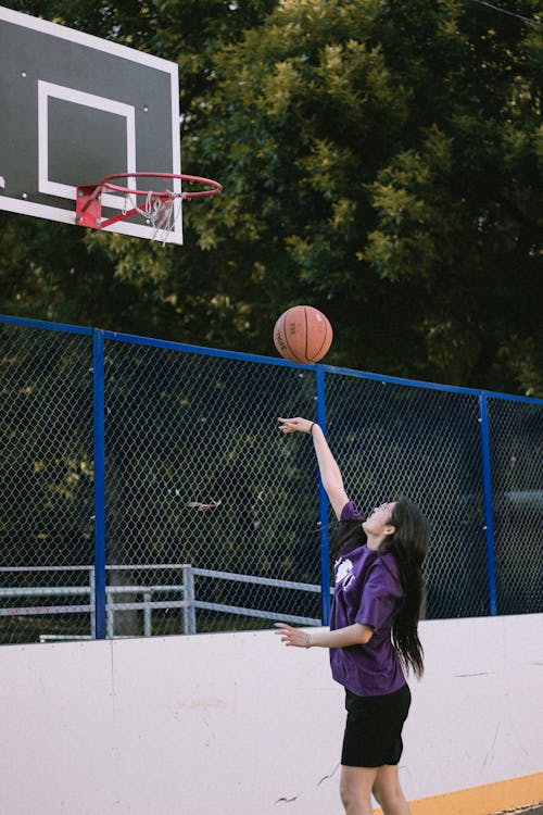 Woman in a Purple Shirt Playing Basketball